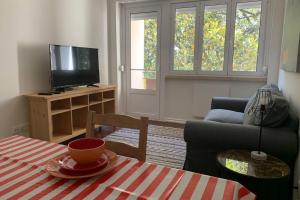 een woonkamer met een tafel en een televisie bij Casa do Largo Sardinha - Very central apartment in Lissabon