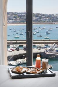 a tray with pastries and coffee and a view of a harbor at Hotel SANSEbay in Donostia-San Sebastián