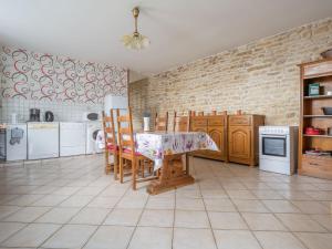 cocina con mesa, sillas y pared de ladrillo en Vintage holiday home with private garden, en Nouart
