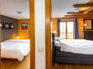 um quarto de hotel com duas camas e uma janela em Ravishing Apartment in La Tzoumaz in Verbier em La Tzoumaz