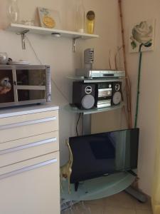 un salon avec une télévision et un four micro-ondes dans l'établissement Traumblick, à Valledoria