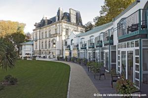 a large building with a lawn in front of it at Clos de Vallombreuse, The Originals Relais in Douarnenez
