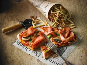 a slice of pizza with a fork and a pile of fries at Holiday Inn Hotel & Suites Calgary South - Conference Ctr, an IHG Hotel in Calgary