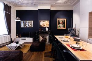 ein Wohnzimmer mit einem Tisch und einem Sofa in der Unterkunft GITADIN - Deluxe Suite Rousseau - Historical center in Lüttich