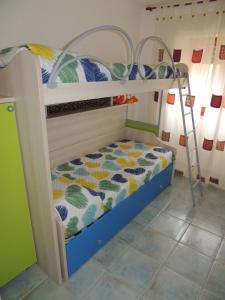 a bedroom with two bunk beds with a ladder at Casa sulla spiaggia in Cala Liberotto
