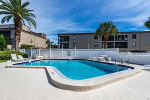 a swimming pool in front of a building at Sunny Condo with Pool Walk to Indian Shores BCH in Clearwater Beach