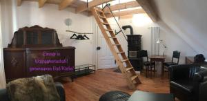 una sala de estar con una escalera de madera y una habitación con una habitación en Privatzimmer Leopold en Sigmaringen