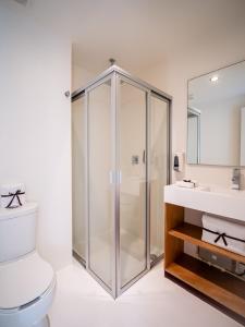 een badkamer met een douche, een toilet en een wastafel bij AM Hotel y Plaza in Santa Cruz Huatulco