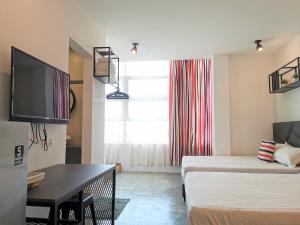 a small living room with a bed and a tv at MWV Suite Room (MUAR) in Muar