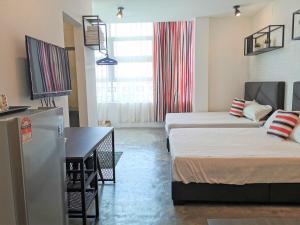 a small room with two beds and a refrigerator at MWV Suite Room (MUAR) in Muar