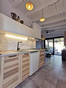 een keuken met witte kasten en een wastafel bij Naturaleza y Arte en la Casa del Molino in Genalguacil