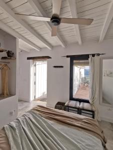 a white bedroom with a ceiling fan and a bed at Naturaleza y Arte en la Casa del Molino in Genalguacil +19 photos