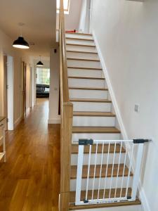 a staircase in a house with white walls and wooden floors at No. 20 An tOileán in Knights Town