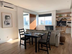 sala de estar con sofá, mesa y sillas en Pine Apartment - a 3m da ciclovia Guincho en Cascais