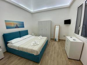 ein Schlafzimmer mit einem blauen Bett, einer Kommode und einem Spiegel in der Unterkunft Casa Blu da Mariano in Marsala