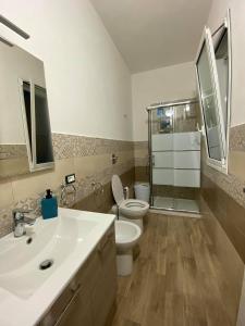 ein Bad mit einem Waschbecken, einem WC und einer Dusche in der Unterkunft Casa Blu da Mariano in Marsala