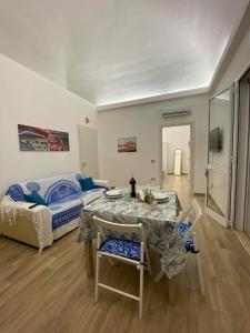 ein Wohnzimmer mit einem Tisch, Stühlen und einem Bett in der Unterkunft Casa Blu da Mariano in Marsala