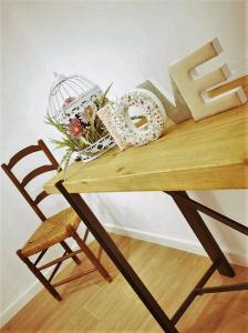 a wooden table with a bird cage and flowers on it at Olívale - Turismo Rural in Campo Maior