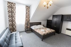 sypialnia z łóżkiem i kanapą w obiekcie Panzió STATUS w Hajduszoboszlo