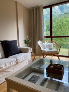 a living room with a couch and a glass coffee table at Apartamento LLAR DEL CARES in Arenas de Cabrales