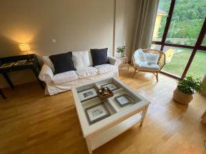 sala de estar con sofá blanco y mesa en Apartamento LLAR DEL CARES, en Arenas de Cabrales
