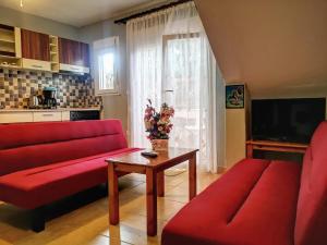 a living room with a red couch and a table at Nikiti Spathies Resort - Ground Apartment at Nikiti Village in Nikiti
