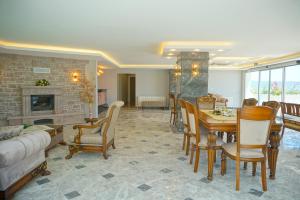 a living room with a table and chairs and a fireplace at Kıvrakzade Otel in Ayvalık