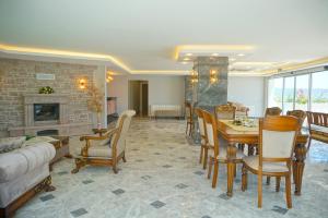 アイワルクにあるKıvrakzade Otelのリビングルーム(テーブル、椅子、暖炉付)