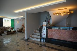 a lobby with a staircase and a living room at Kıvrakzade Otel in Ayvalık