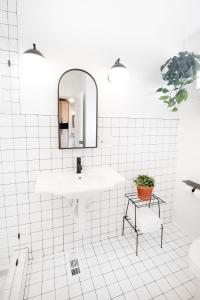 a white bathroom with a sink and a mirror at Modal in Greenville