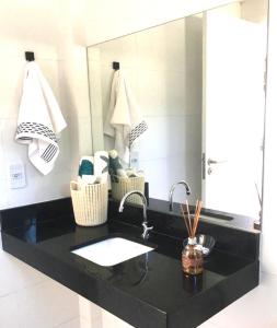 um balcão de casa de banho com um lavatório e um espelho em MILAGRES - Morada do toque em São Miguel dos Milagres
