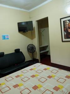 a bedroom with a bed and a flat screen tv at Hostal Virrey & Tours in Trujillo