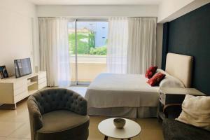 a bedroom with a bed and a chair and a window at Modern Studio between Palermo and Recoleta in Buenos Aires