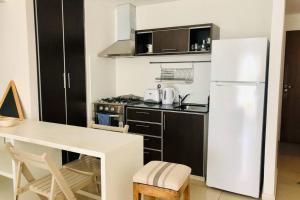 a kitchen with a white refrigerator and a table at Modern Studio between Palermo and Recoleta in Buenos Aires