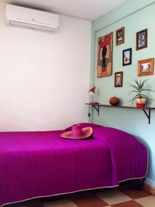 a purple bed with a hat on top of it at Hostel Candelaria in Valladolid