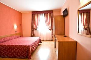 um quarto com uma cama e uma janela em Hotel Colombo em Breda di Piave