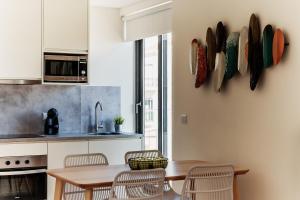 Una cocina con una mesa y sillas de madera. en Sal da Terra, en Nazaré