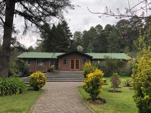 una casa con techo verde y entrada de ladrillo en Hotel Rancho Viejo, en El Aguaje