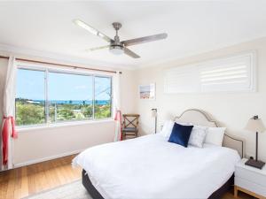 a bedroom with a bed and a large window at Easy Living at 14 Daphne Street in Forster