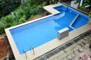 an overhead view of a blue swimming pool with stairs at Hotel H2O in Gampola