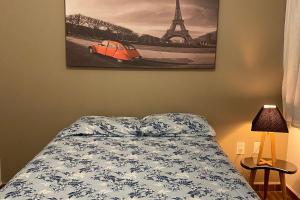 1 dormitorio con 1 cama y una foto de la torre Eiffel en Apartamento novo, completo e bem localizado., en Pirassununga