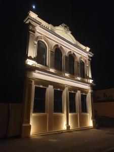 a large white building with a light lit up at night at The Old Confectionery in Oamaru
