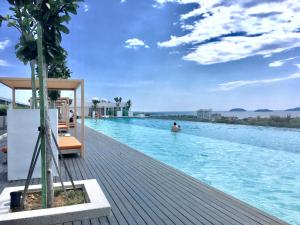 a swimming pool at a resort with people in the water at Homesuite' Home at Sutera Avenue in Kota Kinabalu