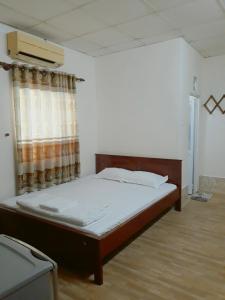 1 dormitorio con 1 cama en una habitación con ventana en Nhà Nghỉ Sugar, en Can Tho