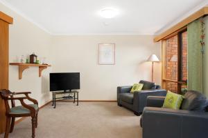 a living room with two couches and a flat screen tv at Jenny Wrens Nest @ Cowes in Cowes