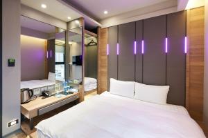 a bedroom with a large white bed and a mirror at KIWI SHARE HOTEL ZHONGLI in Zhongli