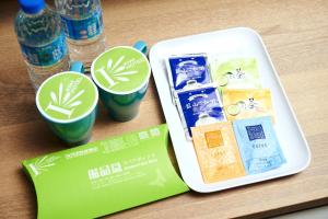 a plastic container with two cups and bottles of water at KIWI SHARE HOTEL ZHONGLI in Zhongli