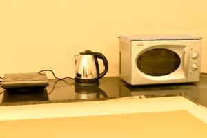 un microondas sentado en un mostrador junto a un horno tostador en Sree Devi Niwas en Chennai