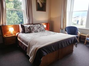 um quarto com uma cama, uma cadeira e uma janela em Te Anau Lodge em Te Anau
