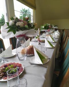 długi stół z talerzami jedzenia i kwiatów na nim w obiekcie Euro w mieście Lyubomlʼ